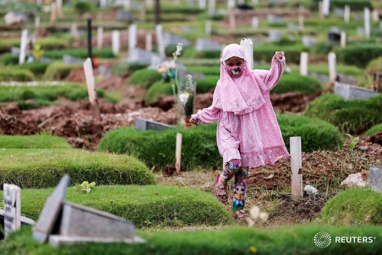 A Muslim girl walks while visiting her relative’s grave, who passed away last ye