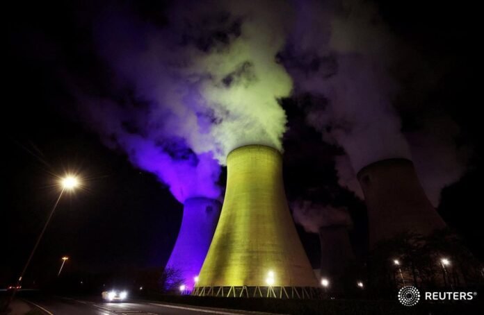 A car drives past the Drax Power Station, illuminated in the colors of the Ukrai