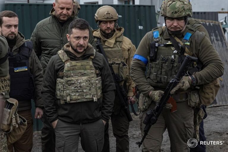 Ukrainian servicemen surround Ukraine’s President Volodymyr Zelenskiy as he visi