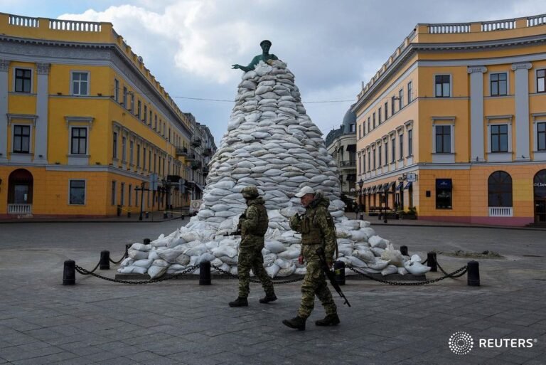 Ukrainian soldiers in Odessa walk past a monument of the city founder Duke de Ri