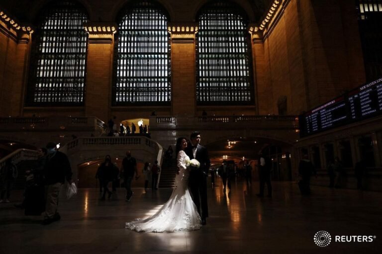 A couple poses for wedding photographs inside Grand Central Station in New York