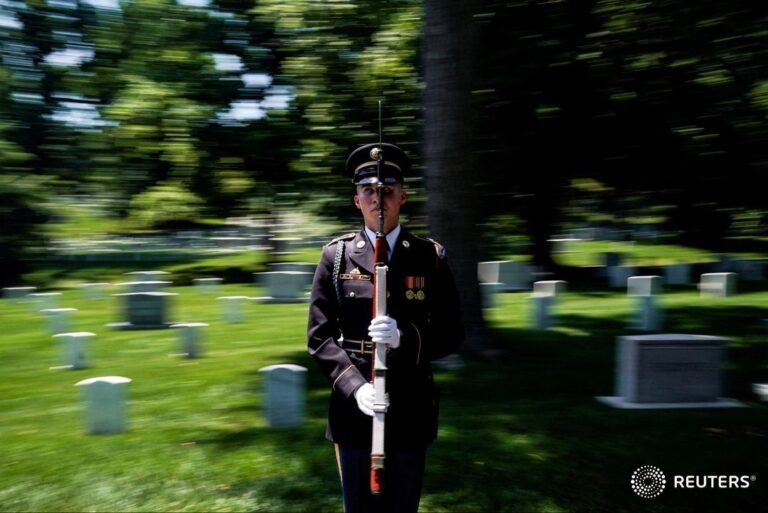 A soldier stands at attention as the motorcade carrying President Joe Biden pass