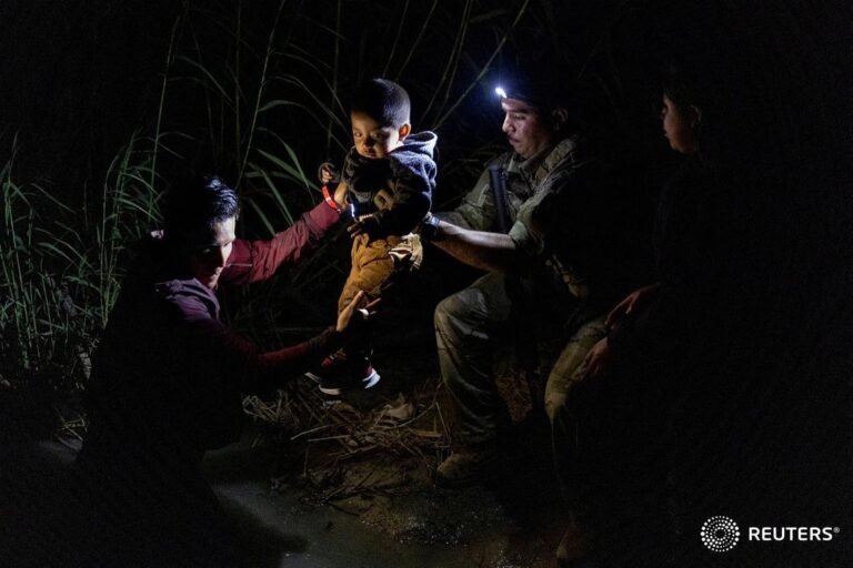 A member of the Texas Army National Guard helps grab 2-year-old Juan Miguel of G